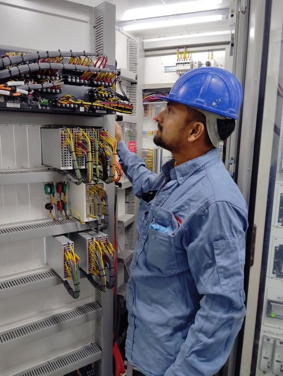Electrician working at an electrical control panel